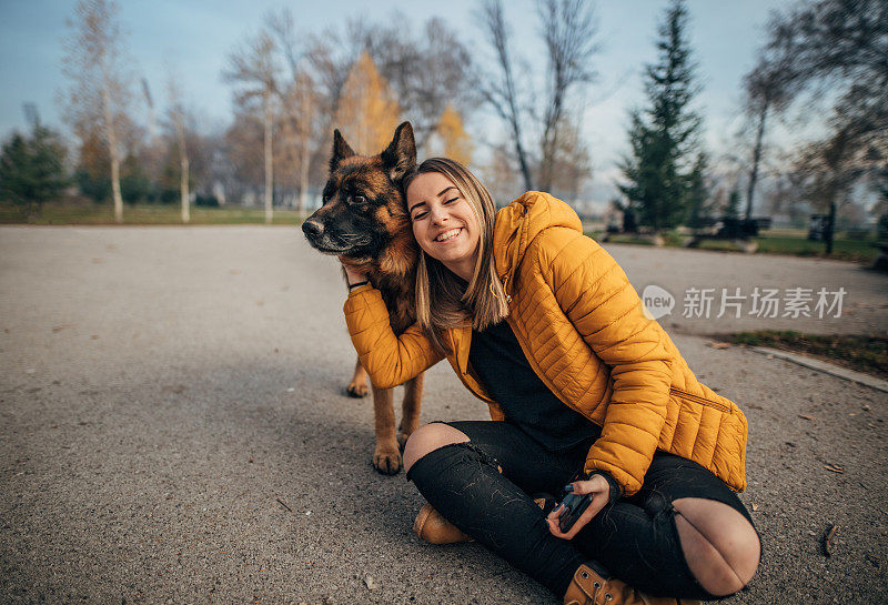 公园里有个年轻女人和一只德国牧羊犬