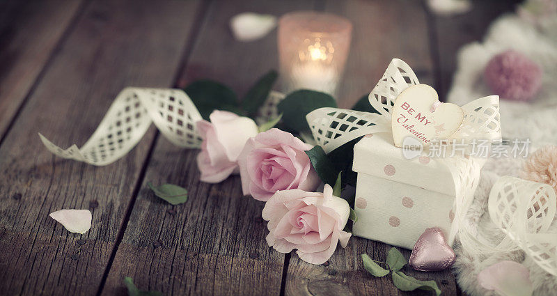 情人节玫瑰和一个礼物在一个老木头的背景