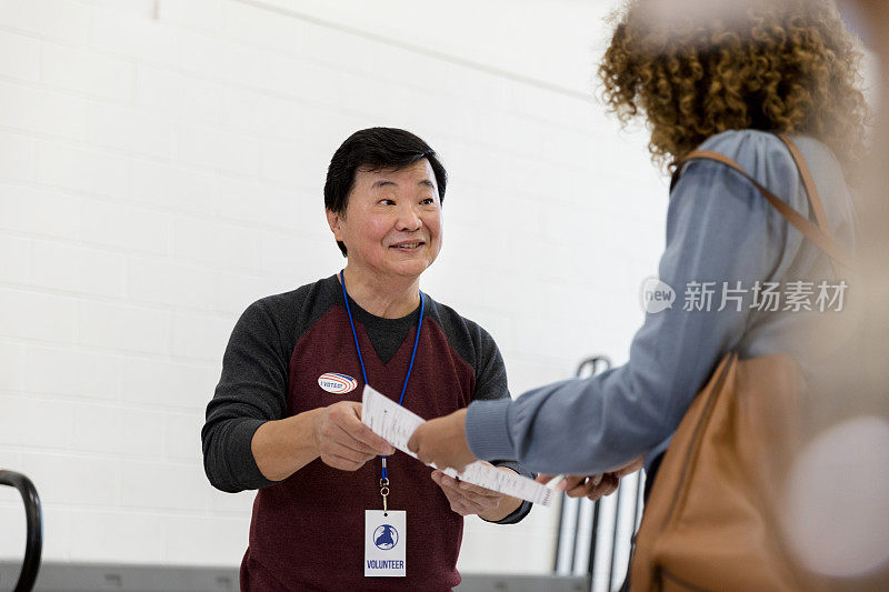 成熟的志愿者微笑着从一个女人手里接过文件