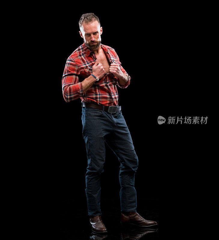 白人男性脱衣舞娘站在前面的黑色背景穿着衬衫