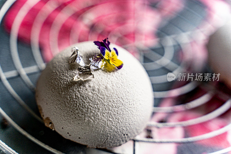特写新鲜美味的自制圆顶甜点装饰可食用的花和金叶-储存照片