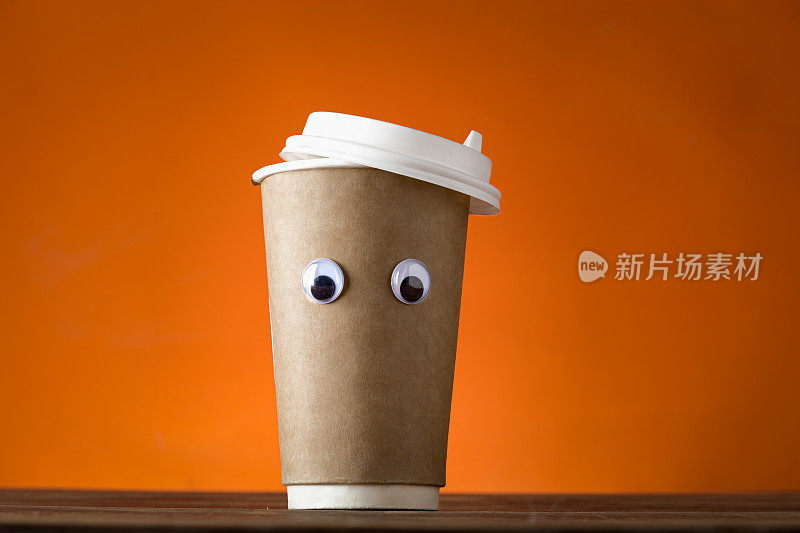 有创意的咖啡杯，橙色背景上有有趣的眼睛