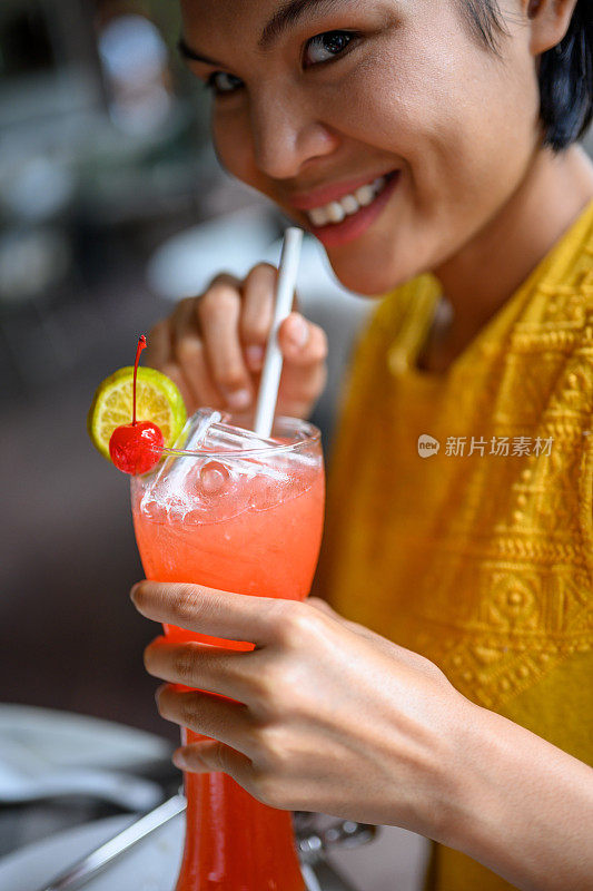 啜饮热带鸡尾酒的女人