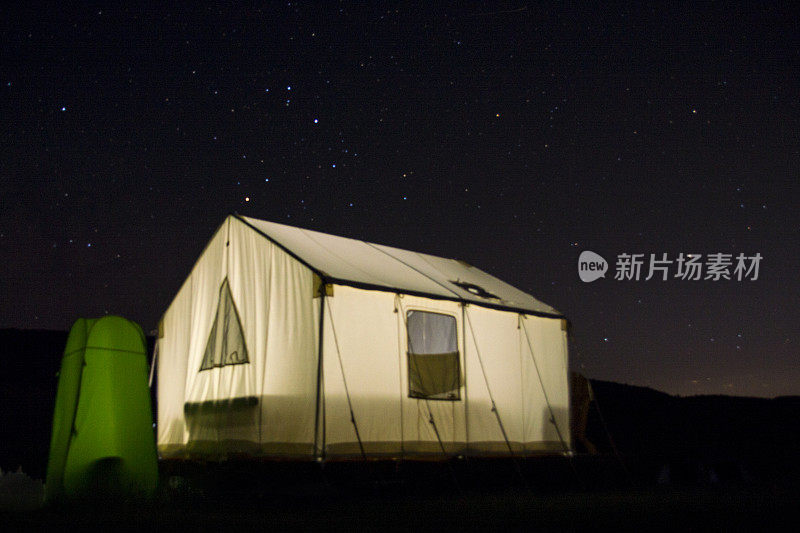 露营帐篷在山上的一个湖，在夜空和星星下发光