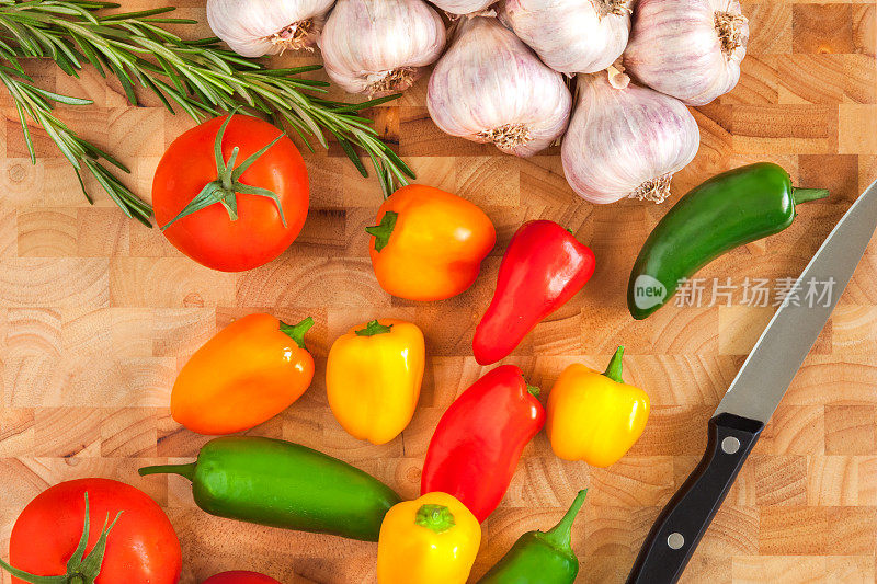 切菜板上放大蒜，辣椒，西红柿，迷迭香和刀(P)