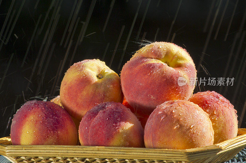 篮子里的成熟桃子被雨水打湿了。