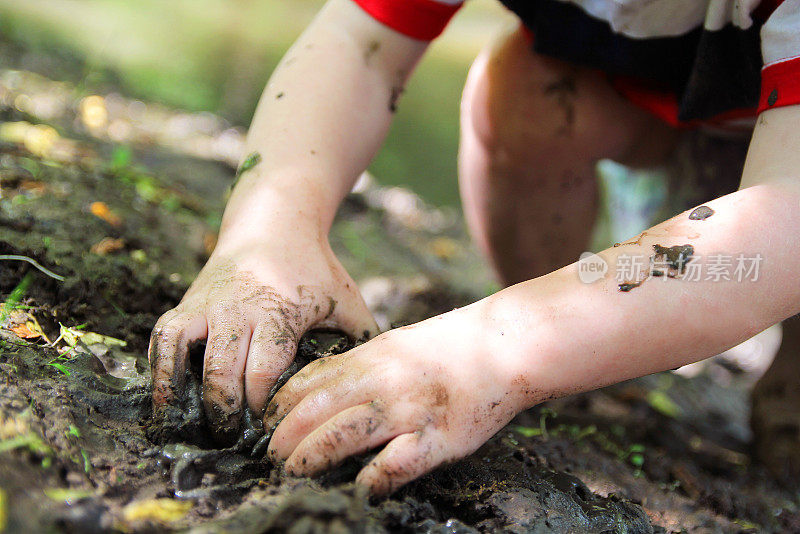 小孩的手在泥里挖