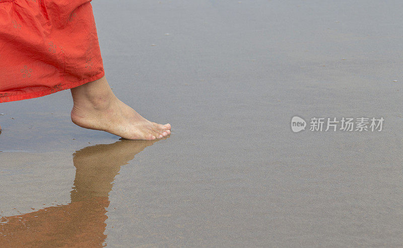 女孩光着脚走在沙滩上