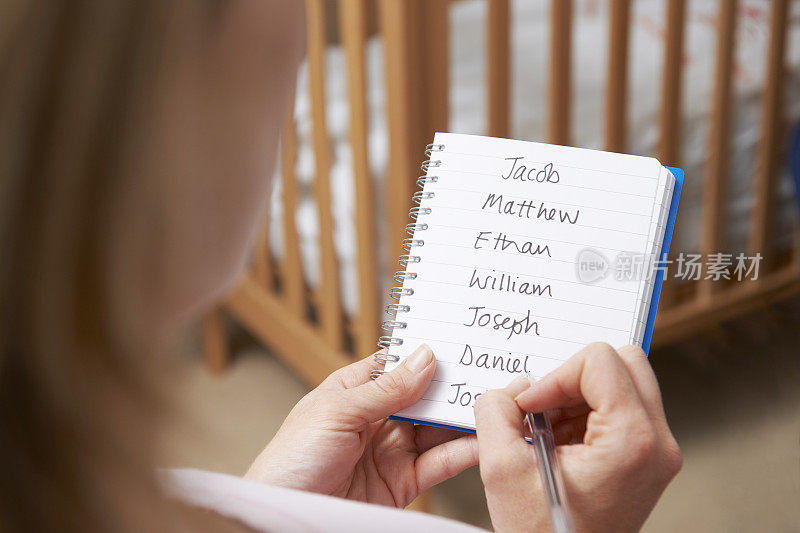 一名妇女正在为托儿所里的男婴写可能的名字