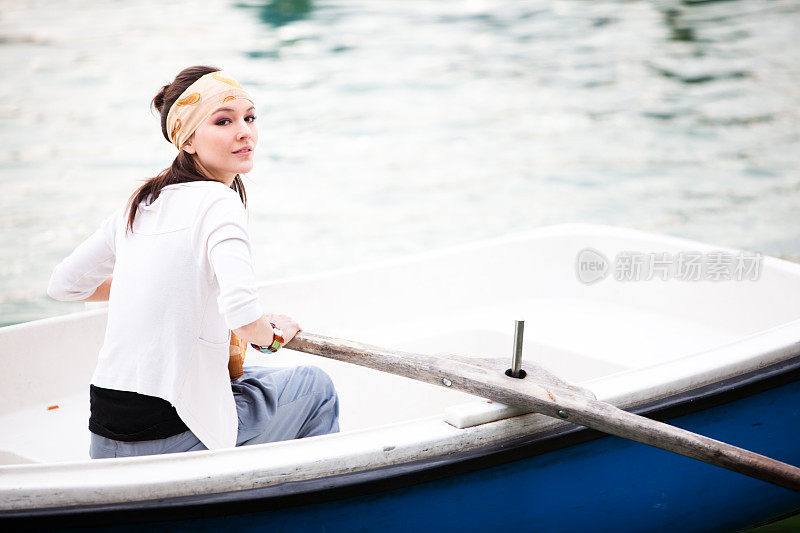 年轻美丽的女人在马德里划船