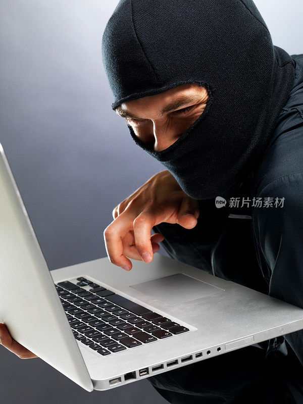 网络犯罪——男性黑客从笔记本电脑窃取信息