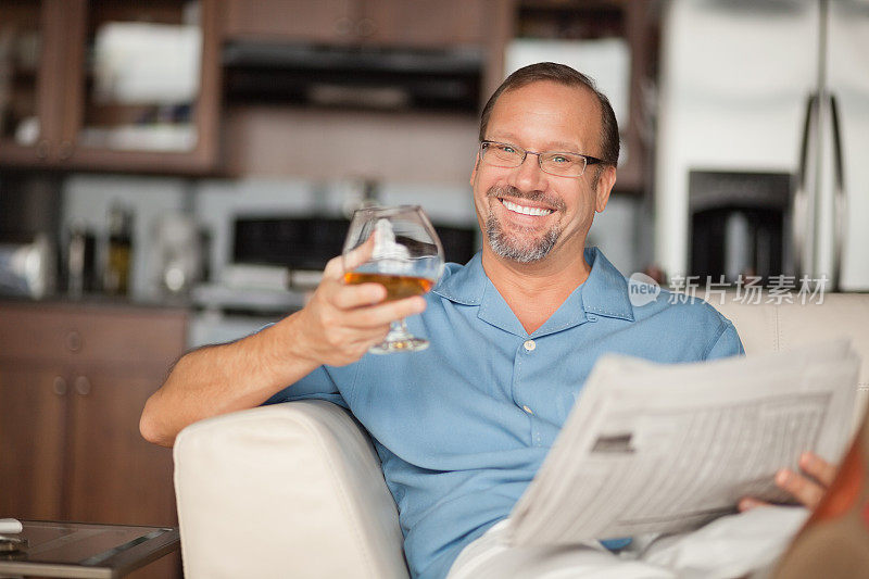 成熟的男人在家里看报纸喝酒放松