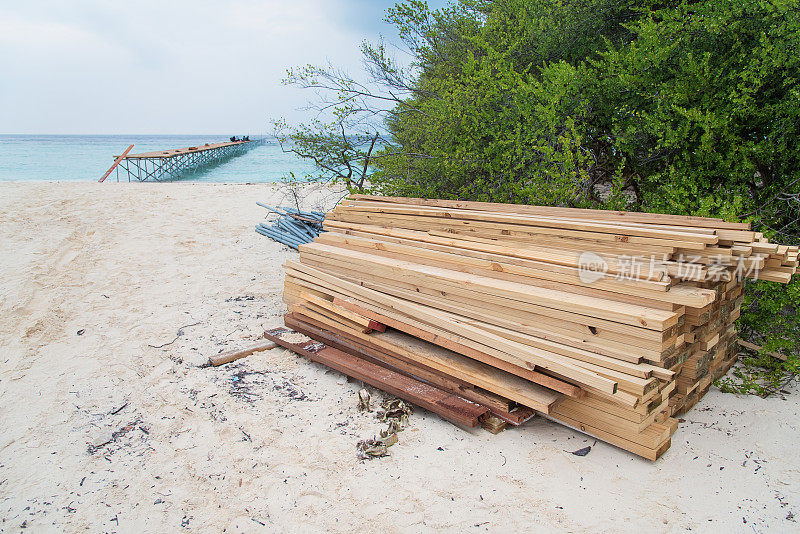 热带海滩上堆积的建筑木材
