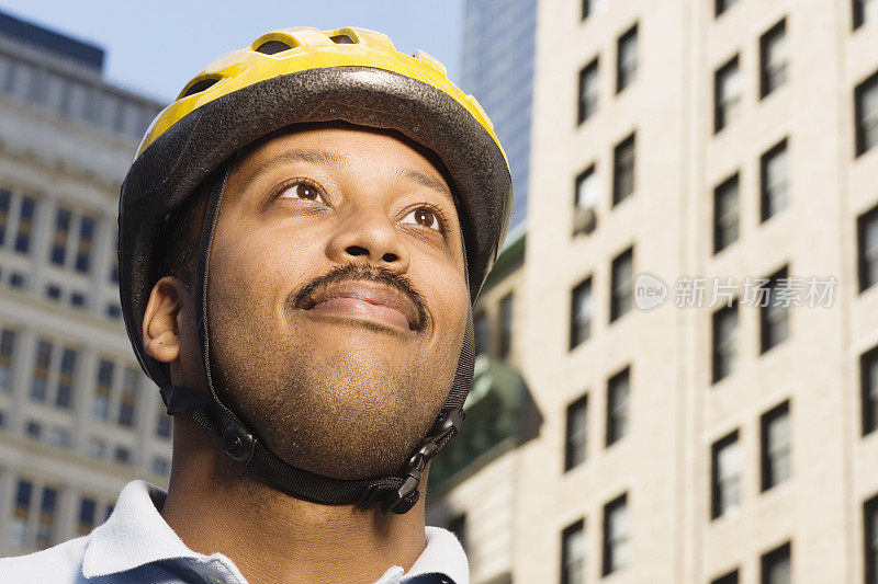 戴着自行车头盔的男人，看向别处