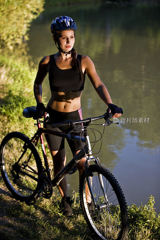 女性山地自行车池塘