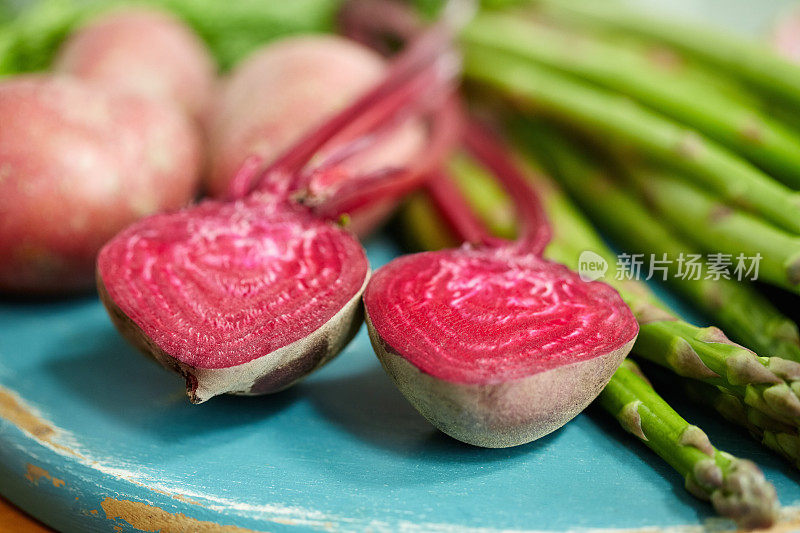 特写:切菜板上切成一半的甜菜根和蔬菜