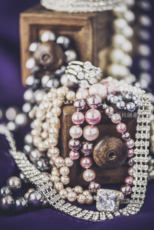 钻石和珍珠珠宝收集在丰富的紫色缎子