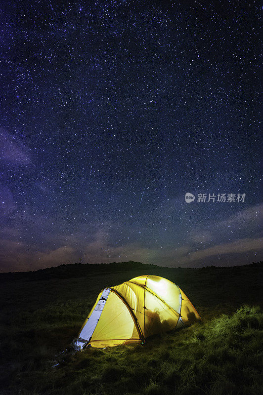 星星在高山上温暖发光的帐篷上闪耀
