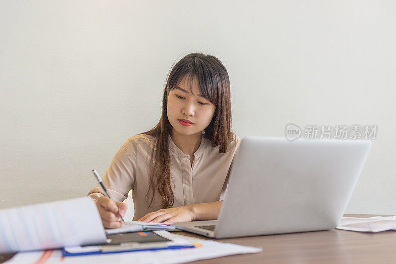 特写女商人在她的办公室手写笔记