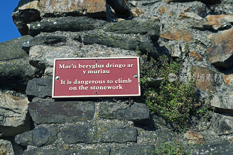 标志张贴在历史悠久的中世纪小镇墙在康威威尔士