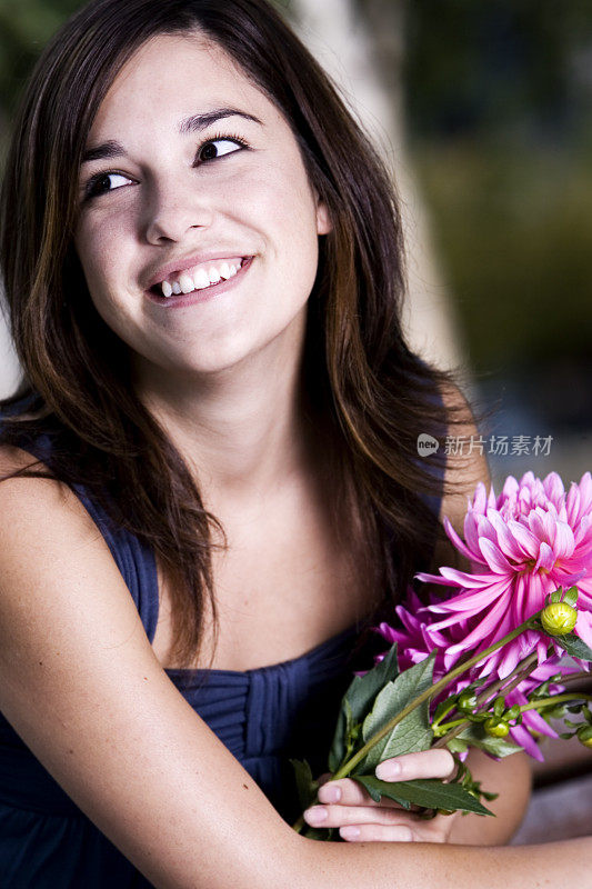 美丽微笑的年轻女子与鲜花，斜视，拷贝空间