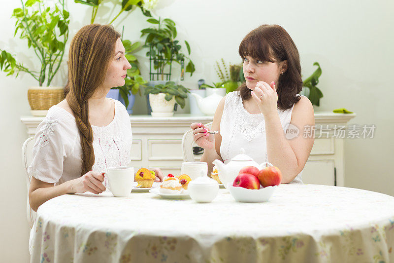 年轻女人在咖啡馆喝茶聊天