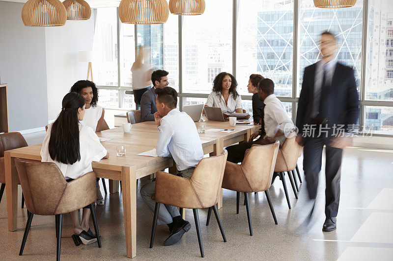 一群商务人士围坐在会议室的桌子旁