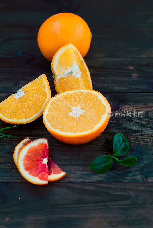 玻璃橙汁和一组橘子在深色的板上