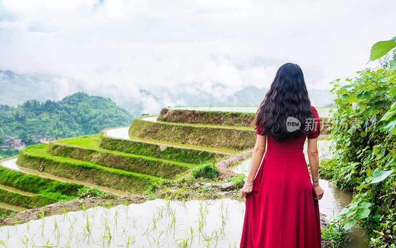 穿着红裙子的女孩欣赏着梯田的景色