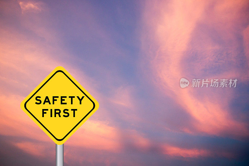黄色交通标志以紫云天空为背景，安全第一