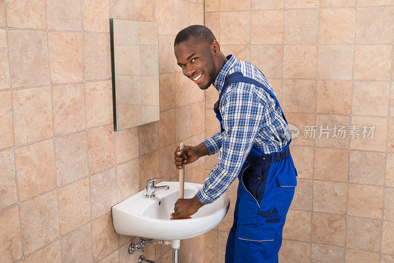 水管工在浴室水槽中使用活塞