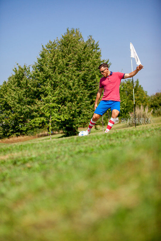 年轻的足球高尔夫运动员打击足球