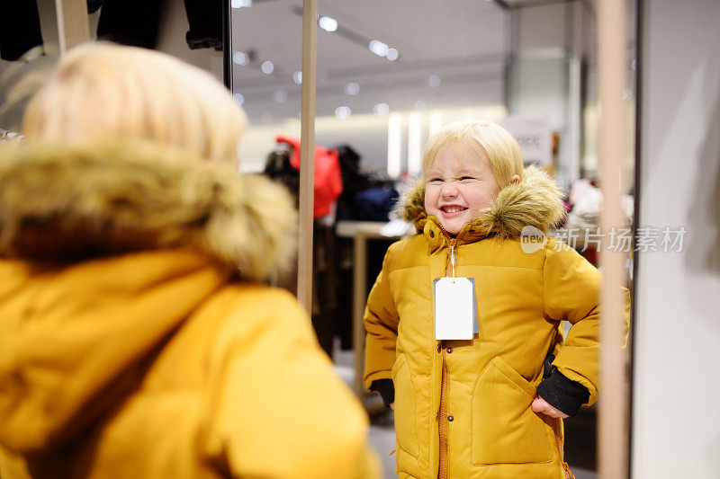 可爱的小男孩在购物时试穿新外套