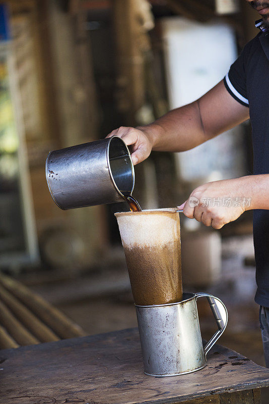 一名男子正在用传统的泰国方式过滤咖啡
