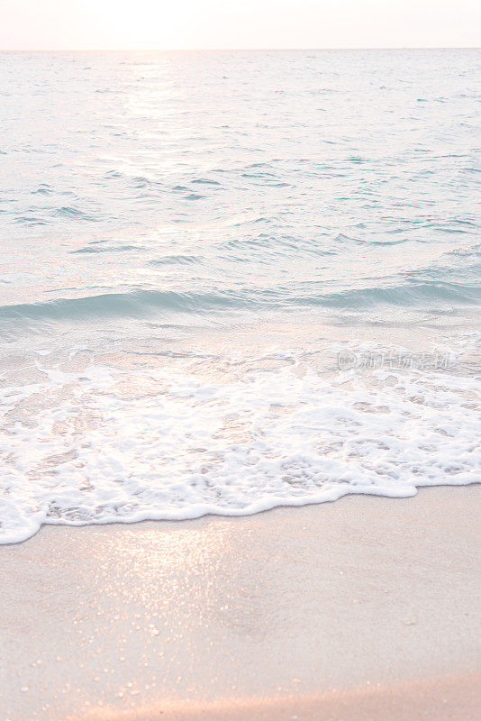 柔和的蓝色海浪在棕榈滩的岸边