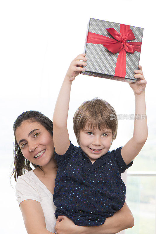 可爱的男孩和他的妈妈与礼品盒