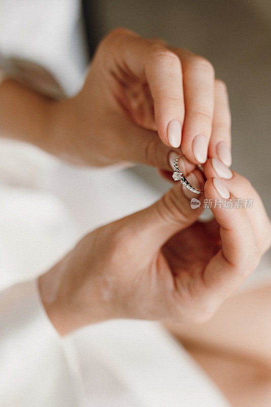 新娘手里拿着一枚镶有宝石的订婚戒指
