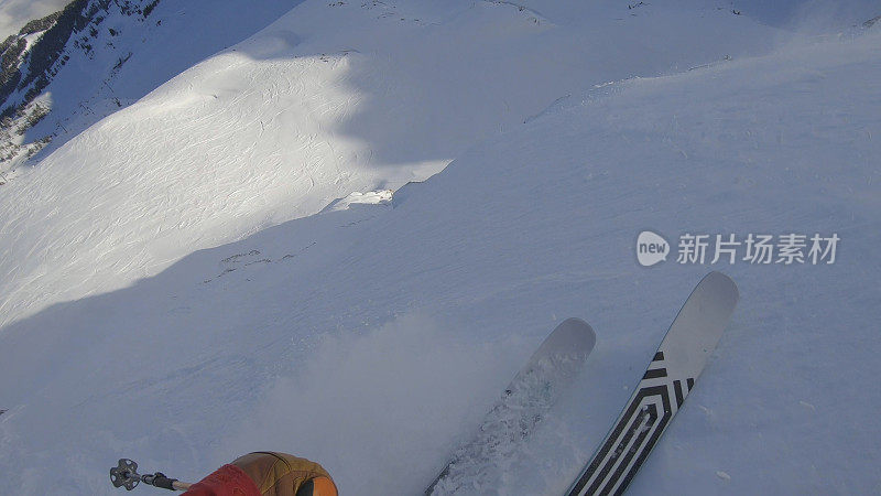 当滑雪者穿过厚厚的粉雪下斜坡时的POV