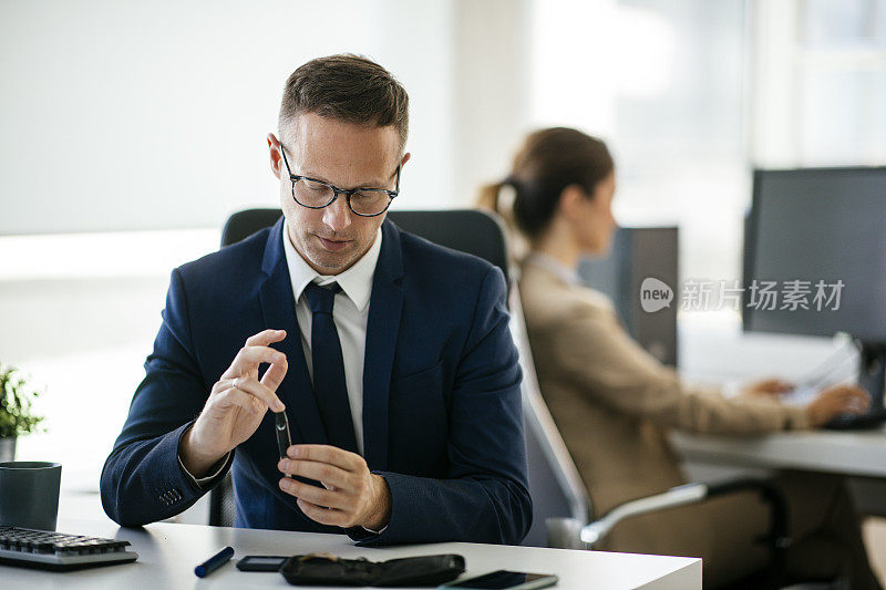 近距离的商人使用柳叶刀钢笔在办公室库存照片