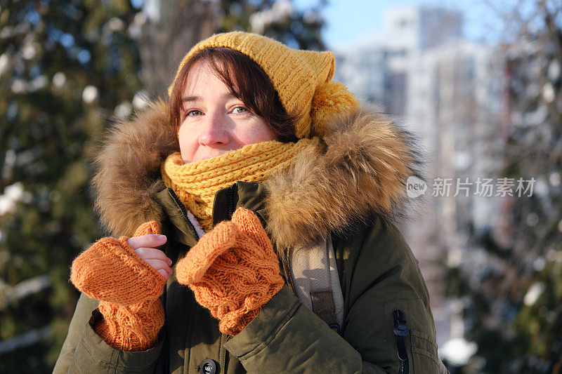 冬天的街上，一个女人在戴手套
