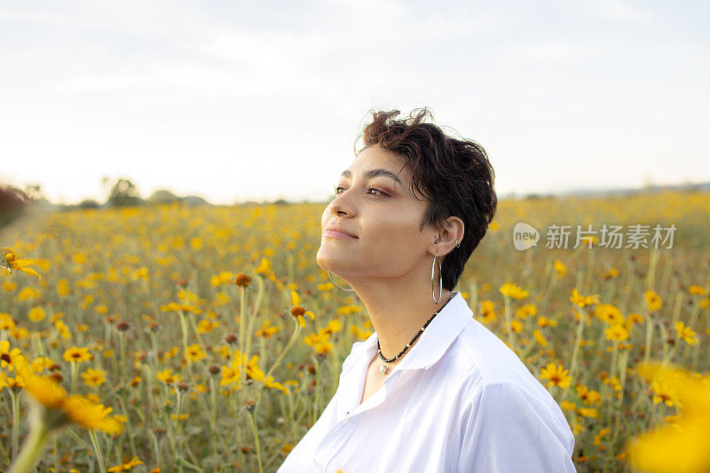 一个年轻女子的肖像在花坛，在日落