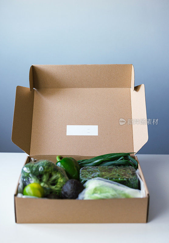 在桌子上装有新鲜蔬菜和水果的盒子
