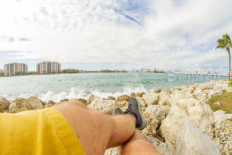 一个年轻的运动男子在南海滩，迈阿密海滩，迈阿密，美国南佛罗里达的南角公园休息的视角镜头