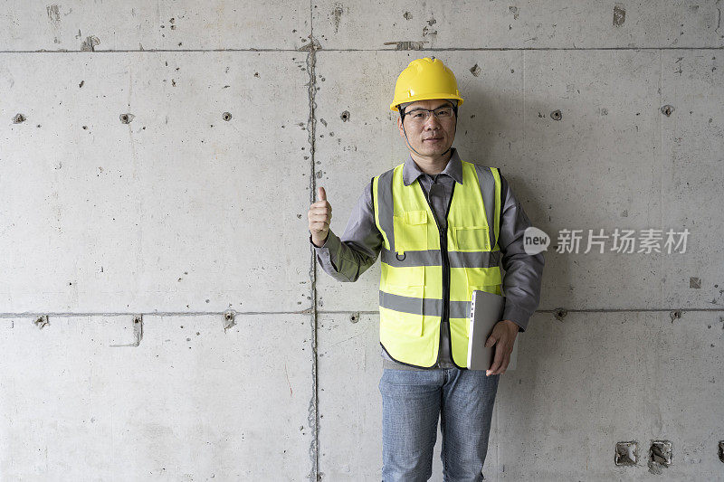 一名亚洲男性工程师在建筑工地使用平板电脑