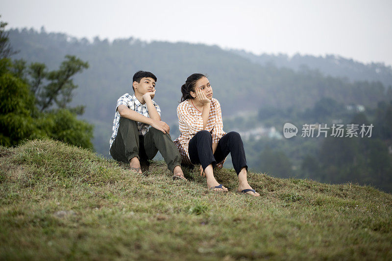 十几岁的男孩和女孩在山上欣赏户外景色