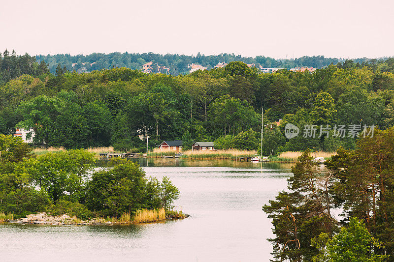 瑞典。夏日海岸上美丽的瑞典木屋。湖泊或河流景观