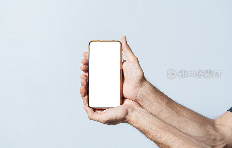 在手机上展示广告的手。双手分开显示手机屏幕。双手显示手机白色屏幕。双手合十，显示手机屏幕