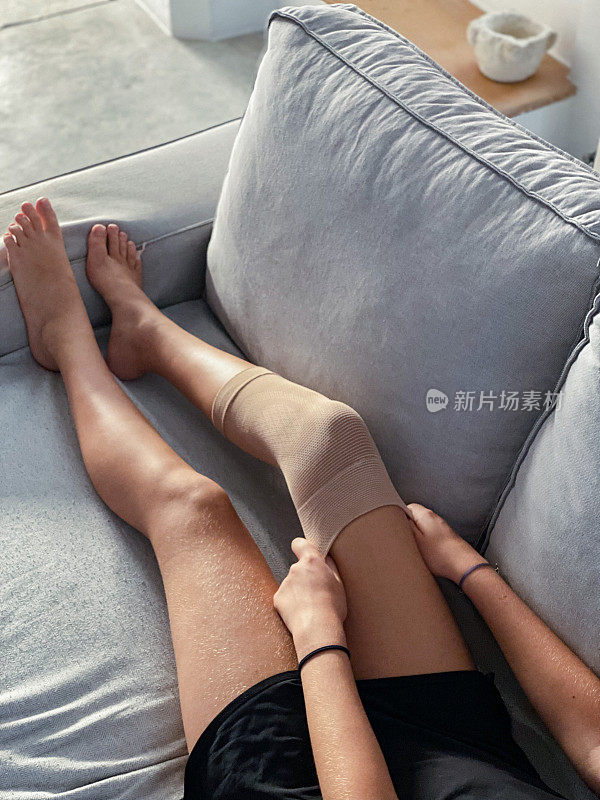 意外发生了:女孩在沙发上休息，戴上了护膝