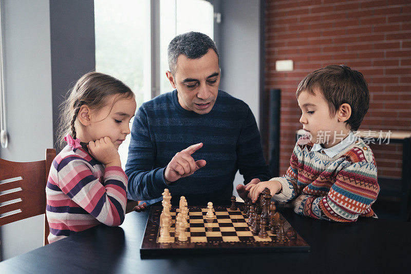 父亲和孩子们在家里下棋