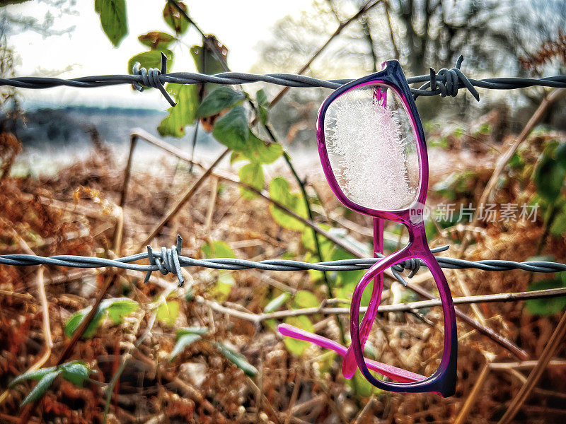 粉红色的眼镜掉在铁丝网上了